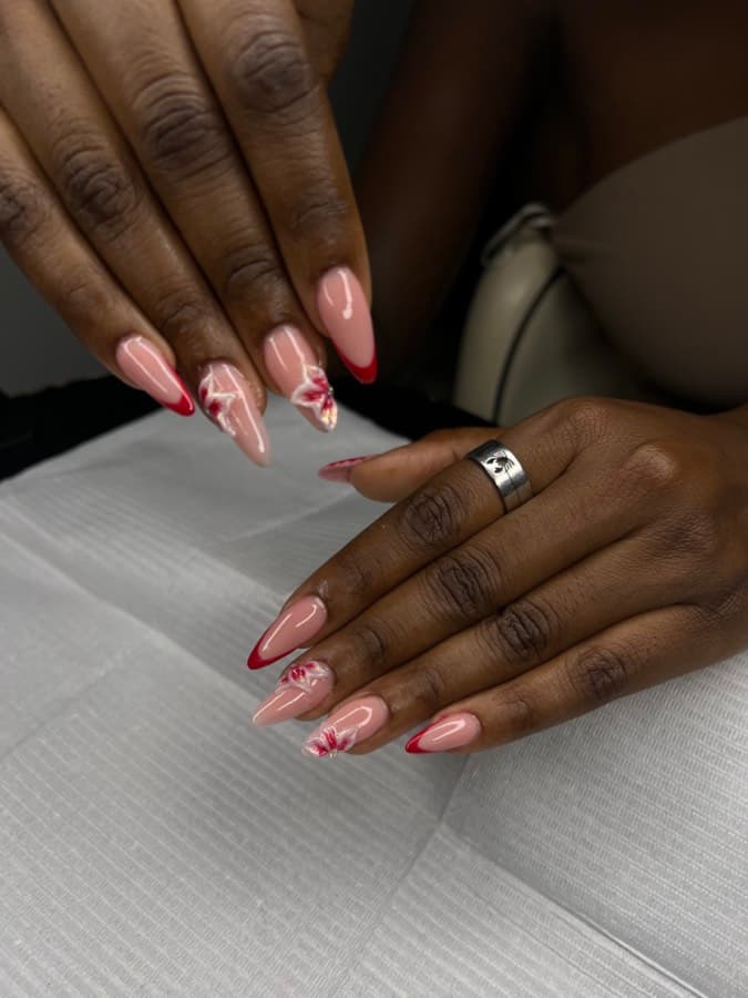 Pose gel nude avec nail art floral et liseré rouge